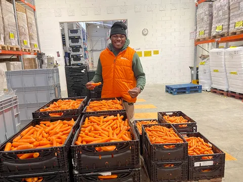 Kam Nganssoh Gildas benevole a la Banque Alimentaire, caisses de legumes